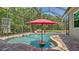 Screened-in pool featuring a rock waterfall, seating area, and lush greenery surrounding the backyard oasis at 8019 Indigo Ridge Ter, Bradenton, FL 34201