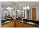 Bathroom with double sinks, granite countertop, wood cabinets, and large mirrors at 8045 Tybee Ct # 8045, University Park, FL 34201