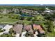 Aerial view of golf course community with lush landscaping, a pond, and well-maintained homes at 8771 52Nd E Ave, Bradenton, FL 34211