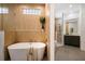 Bathroom boasts wood look ceramic tile, glass enclosed shower, and a luxurious soaking tub at 8771 52Nd E Ave, Bradenton, FL 34211