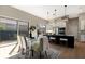 Open-concept kitchen features a glass-top dining table, modern stainless steel appliances, and island seating at 8771 52Nd E Ave, Bradenton, FL 34211