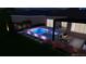 Backyard pool with lights and patio featuring an outdoor kitchen area at dusk at 8771 52Nd E Ave, Bradenton, FL 34211