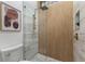 Modern shower with marble and wood accents, complete with updated fixtures and a glass door at 8771 52Nd E Ave, Bradenton, FL 34211