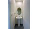 Powder room with pedestal sink, oval mirror, and neutral wall color at 8864 Milestone Dr, Sarasota, FL 34238
