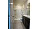 Bathroom with double sink vanity, framed mirrors, a step-in shower with glass door, and tile flooring at 8864 Milestone Dr, Sarasota, FL 34238