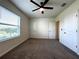 Bedroom featuring carpet, ceiling fan, and a large window that allows ample natural light at 8864 Milestone Dr, Sarasota, FL 34238