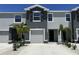 Charming two-story townhome featuring a one-car garage, dark shutters, and well-manicured landscaping at 8864 Milestone Dr, Sarasota, FL 34238