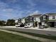 A row of gray townhomes, each with a one car garage and simple landscaping at 8864 Milestone Dr, Sarasota, FL 34238