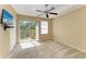 Cozy bedroom featuring neutral walls, plush carpet, a ceiling fan, and a sliding door to the balcony at 8943 White Sage Loop, Lakewood Ranch, FL 34202