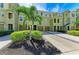 Attractive green townhouse showcasing individual driveways, garage doors, and tropical landscaping at 8943 White Sage Loop, Lakewood Ranch, FL 34202