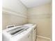 Bright laundry room featuring a front-loading washer and dryer, plus ample shelving for storage and organization at 8943 White Sage Loop, Lakewood Ranch, FL 34202