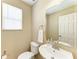 Updated powder room with a modern sink, mirror, and fixtures, and a window that provides natural light at 8943 White Sage Loop, Lakewood Ranch, FL 34202