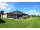 Spacious, grassy backyard, featuring a screened-in pool, and surrounded by well-maintained landscaping at 9112 63Rd E Ct, Parrish, FL 34219