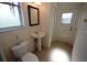 Powder room featuring a pedestal sink, toilet, framed mirror, and an exit door to the outside at 9112 63Rd E Ct, Parrish, FL 34219