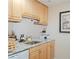 Granite countertops, stainless sink, and wooden cabinets in the kitchen create a warm feel at 3269 Beneva Rd # 102, Sarasota, FL 34232