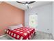 Bright bedroom featuring a fan, red and white bedding, and a view of the yard at 10860 79Th E St, Parrish, FL 34219