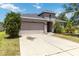 Inviting home featuring a two-car garage, arched entrance, and landscaped front yard at 10860 79Th E St, Parrish, FL 34219