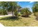Inviting home showcasing a well-maintained lawn, palm trees, and manicured landscaping at 10860 79Th E St, Parrish, FL 34219