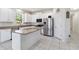 Bright kitchen with white cabinets, stainless appliances, granite counters, and tile floors at 10860 79Th E St, Parrish, FL 34219