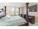 Comfortable main bedroom with a four-poster bed, TV, and view of the backyard at 10860 79Th E St, Parrish, FL 34219