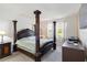 The main bedroom features an ornate four-poster bed, side tables, and two windows at 10860 79Th E St, Parrish, FL 34219
