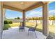 Relaxing covered patio featuring a serene outdoor seating area and a tranquil view of the manicured backyard at 10860 79Th E St, Parrish, FL 34219