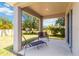 Covered patio with comfortable seating area, perfect for relaxing and enjoying the beautiful backyard view at 10860 79Th E St, Parrish, FL 34219