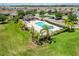 Community pool with lounge area surrounded by lush landscaping and palm trees, ideal for relaxation and recreation at 10860 79Th E St, Parrish, FL 34219
