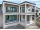 This image displays the back of a modern house with large windows and an unfinished patio at 114 Fillmore Dr, Sarasota, FL 34236