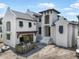 Exterior of modern two-story home featuring a light-colored facade, covered entry, and unfinished landscaping at 114 Fillmore Dr, Sarasota, FL 34236