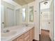Bathroom with double sinks, large mirror, wood-look flooring, and plenty of cabinet storage space at 1310 91St Nw Ct, Bradenton, FL 34209