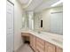 Bathroom with double vanity and sinks, storage, large mirror, and clean aesthetic design at 1310 91St Nw Ct, Bradenton, FL 34209