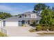 Charming two-story blue home with a spacious two-car garage, a well-kept lawn, and a welcoming front entrance at 1310 91St Nw Ct, Bradenton, FL 34209