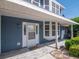 Inviting front porch with wood-look tile, a covered entryway, and charming details accentuating the blue exterior at 1310 91St Nw Ct, Bradenton, FL 34209