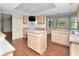 Kitchen features wood floors, cabinets, an island, and a modern stovetop with decorative tile backdrop at 1310 91St Nw Ct, Bradenton, FL 34209