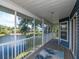 Inviting screened porch features a scenic waterfront view, ceiling, and wood flooring with outdoor rug at 1310 91St Nw Ct, Bradenton, FL 34209