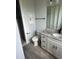 Bathroom with modern vanity, gray granite countertop, toilet, and a walk-in shower at 14343 Myakka Ave, Port Charlotte, FL 33953