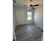 Bedroom showcasing gray wood-look floors, a window, and sliding closet doors at 14343 Myakka Ave, Port Charlotte, FL 33953