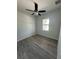 Bedroom showcasing gray floors, a ceiling fan, and bright window at 14343 Myakka Ave, Port Charlotte, FL 33953