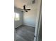 Cozy bedroom featuring a ceiling fan, gray wood-look floors, and a bright window at 14343 Myakka Ave, Port Charlotte, FL 33953