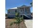 Charming two-story home with elevated porch and white railings, surrounded by new landscaping at 14343 Myakka Ave, Port Charlotte, FL 33953