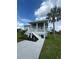 Charming home featuring a welcoming porch, manicured lawn, and a swaying palm tree at 14343 Myakka Ave, Port Charlotte, FL 33953