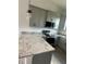 Kitchen details showcasing granite countertops, gray cabinets, and stainless steel appliances at 14343 Myakka Ave, Port Charlotte, FL 33953