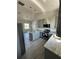 Bright kitchen features gray cabinets, stainless steel appliances, island, and gray wood-look floors at 14343 Myakka Ave, Port Charlotte, FL 33953