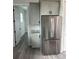 View of the kitchen with cabinets, a stainless steel fridge, and a laundry area at 14343 Myakka Ave, Port Charlotte, FL 33953