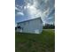 Rear elevation of a house set amidst a lush green landscape under a bright sky at 14343 Myakka Ave, Port Charlotte, FL 33953