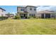 A large backyard featuring a covered patio, lush green grass, and well-maintained landscaping at 16119 Paynes Mill Dr, Bradenton, FL 34211