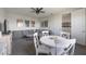 A carpeted bonus room with a ceiling fan, movie posters, a table and a large gray sofa at 16119 Paynes Mill Dr, Bradenton, FL 34211