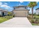 Inviting home featuring a two-car garage, lush landscaping, and a sunny front lawn, perfect for Gathering living at 16119 Paynes Mill Dr, Bradenton, FL 34211
