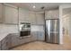 Well-lit kitchen boasts stainless steel appliances, gray cabinetry, and a white backsplash and countertops at 16119 Paynes Mill Dr, Bradenton, FL 34211